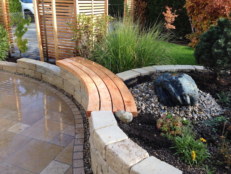 Trockenmauer aus Jura Kalkstein getrommelt mit Sitzauflage aus &ouml;sterreichischer Gebirgsl&auml;rche. Terrassenbelag aus Travertin im r&ouml;mischen Verband. ( Neufahrn - Eching)