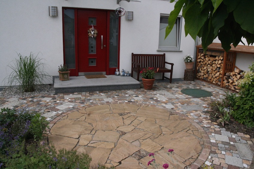 Eingangsbereich mit einem Kreis aus Sandstein und buntem gemischten Pflaster.  (M&uuml;nchen)