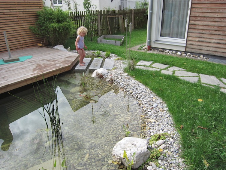 Teich mit über das Wasser ragendem Holzdeck aus Lärche. (München)