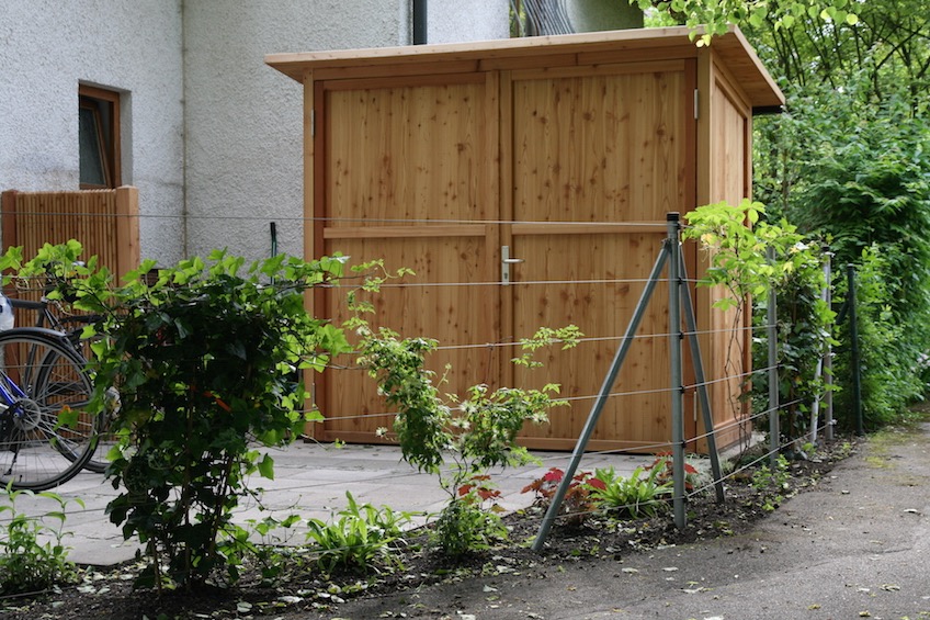 Gartenschrank der Firma Scholbeck. Zaun aus Edelstahlseilen mit Berankung von Kletterpflanzen. (Garching bei München)