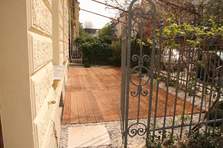 Holzdeck aus Bangkirai mit Kiesbeet. Beschattung mit Stahlseilen, die von Blauregen berankt werden. (München)