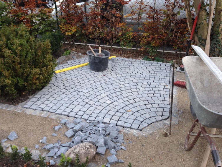 Der Sitzplatz wurde mit dunklem Granit Kleinstein befestigt. (München)