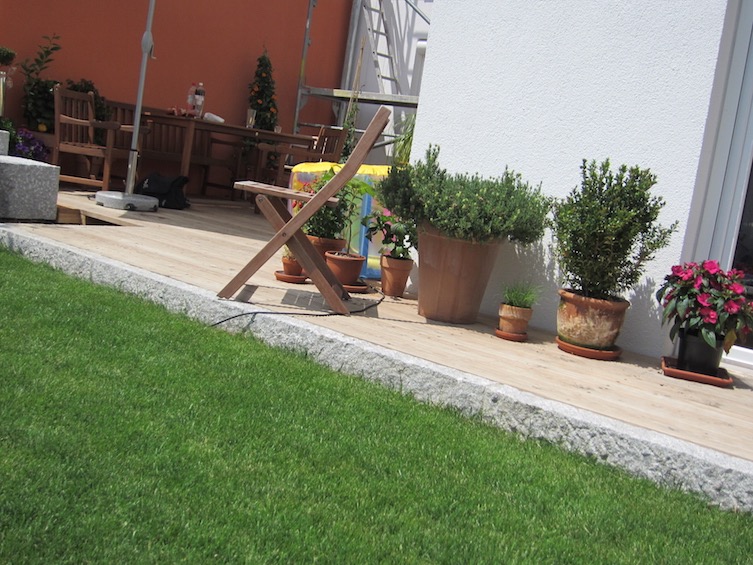 Eine Stufe von der Terrasse auf den Rasen kann optisch sehr reizvoll wirken. (Poing bei München)